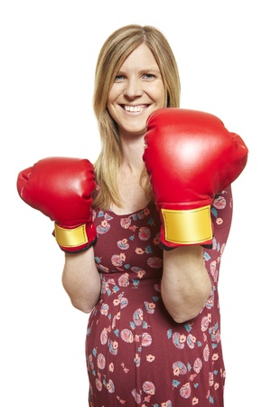 Young woman wearing boxing gloves smiling on white backgroundの写真素材