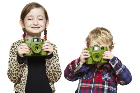 Young boy and girl each holding a camera on white backgroundの写真素材