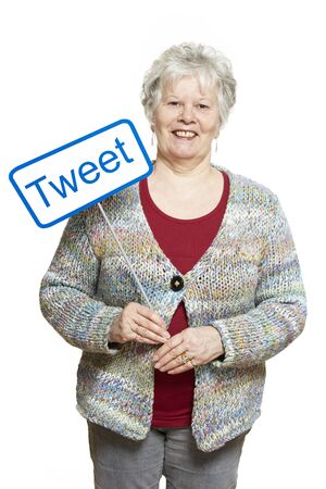 Senior woman holding a social media sign smiling on white backgroundの写真素材