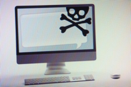 Desktop computer displaying conceptual internet fraud and scam warning on screenの写真素材