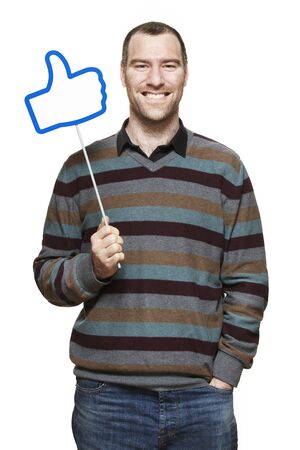 Young man holding a social media sign smiling on white backgroundの写真素材