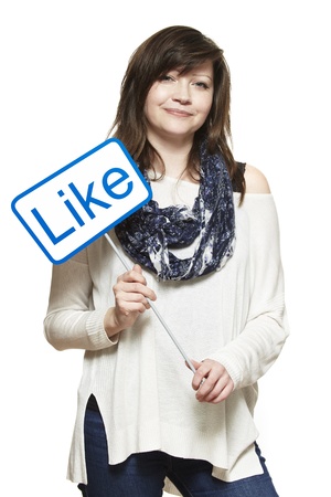 Young woman holding a social media sign smiling on white backgroundの写真素材