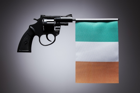 Gun crime concept of hand pistol showing the flag of irelandの写真素材