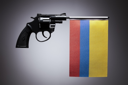 Gun crime concept of hand pistol showing the flag of colombiaの写真素材