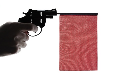 Gun crime concept of hand pistol showing a blank red flagの写真素材