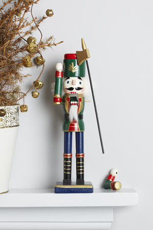 Christmas nutcracker solider broken on mantle piece with decorated dead pine tree  Unhappy xmas conceptの写真素材