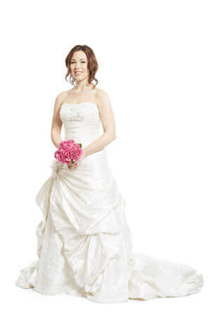 Female bride holding a wedding bouquet of pink roses on white background smilingの写真素材