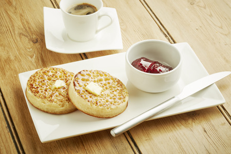 Crumpets toasted on white dish and wooden table topの写真素材