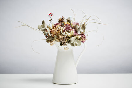 Bridal flowers dried in vase on white table topの写真素材
