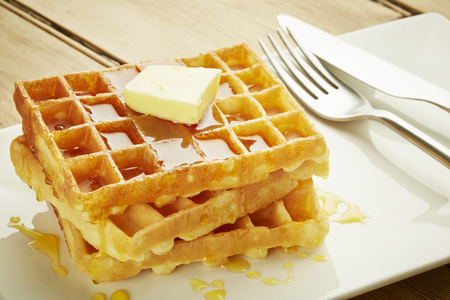 Waffles with syrup on white dish and wooden table topの写真素材