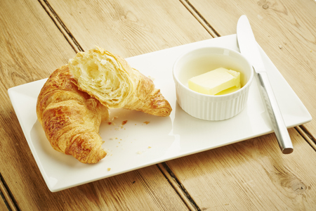 Croissant pastry on white dish and wooden table topの写真素材