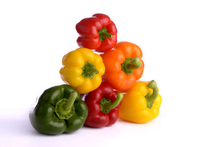 seven sweet pepper fruits of different color, isolated, white background, lying on each other, stapledの写真素材