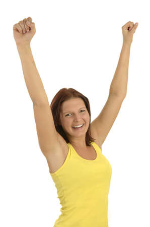 Young woman in a yellow tank top stretching arms and smiling, white background, portrait, isolatedの写真素材
