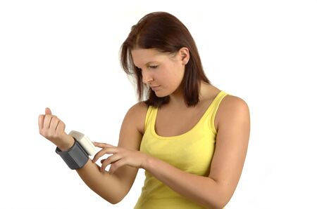 Young sporty woman in a yellow tank top controls blood sugar levels on the meterの写真素材