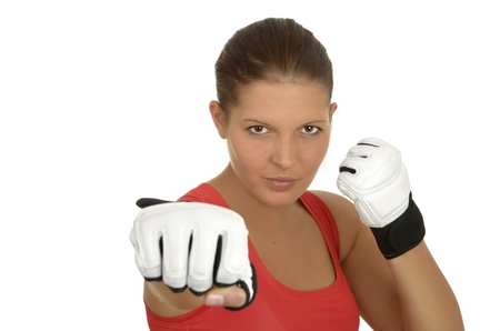 Young beautiful sportswoman in a red top with kick boxing gloves and a determined look in front of white background, landscape format, studio shotの写真素材