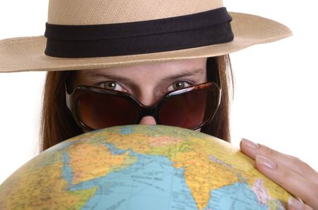 young woman with travelling hat, sunglasses and globe lokks into the camera, isolated, white background, close upの写真素材