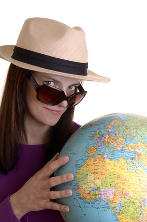 young woman with strawhat, sunglasses and hat is holding a globe, isolated, white backgroundの写真素材