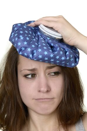 young woman with ice pad before white background, isolated, studio shotの写真素材