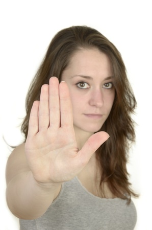 young woman shows open hand before white background, idolated, studio shotの写真素材