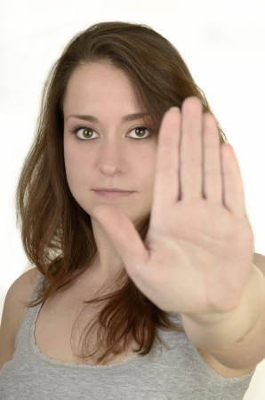 young woman shows open hand before white background, idolated, studio shotの写真素材