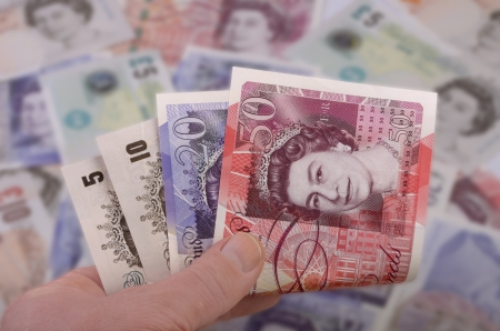 hand holds british banknotes pounds, studio shotの写真素材