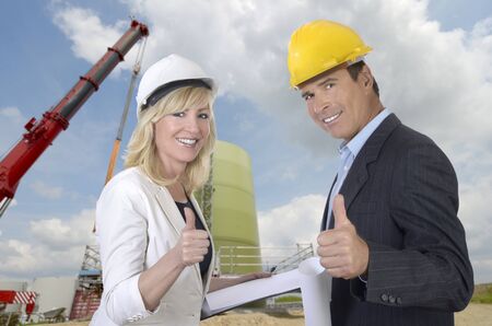 Male and female architect and construction site smiling and thumb up, outdoor