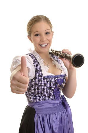 Pretty woman in dirndl dress with saxophone, thumb up, Studio Shotの写真素材