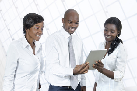 Three african business people with tablet PC, Studio Shotの写真素材