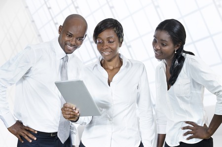 Three african business people with tablet PC, Studio Shotの写真素材
