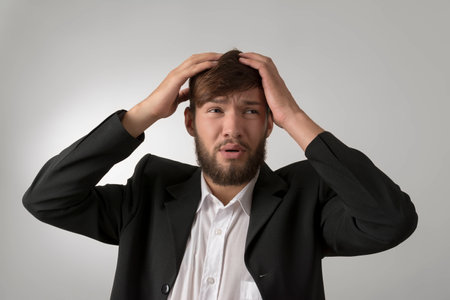 Young man in unfortunate situation, studio shot