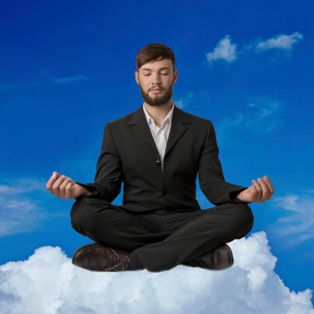 Young man meditating on a cloud, studio shotの写真素材