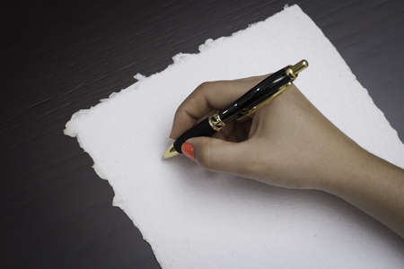 Woman about to write on a recycle black paperの写真素材