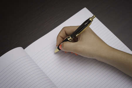 Woman about to write on a black note paperの写真素材