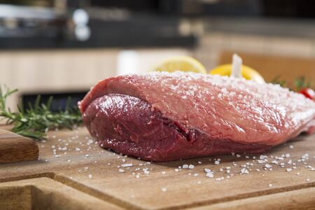 raw steak on wooden board with tomatoの写真素材