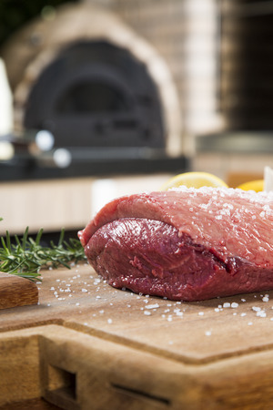 raw steak on wooden board with tomatoの写真素材