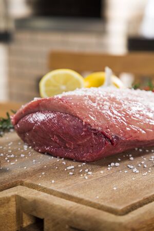 raw steak on wooden board with tomatoの写真素材