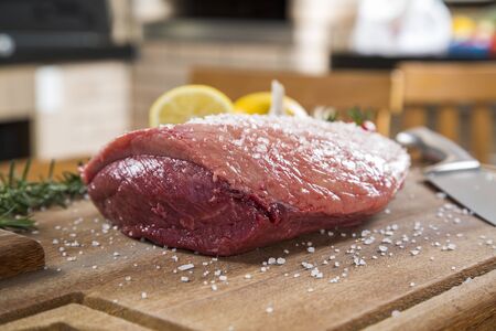 raw steak on wooden board with tomatoの写真素材