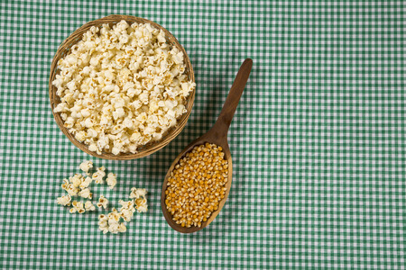 Ear of corn, revealing yellow kernels of maize in a wicker basketの写真素材