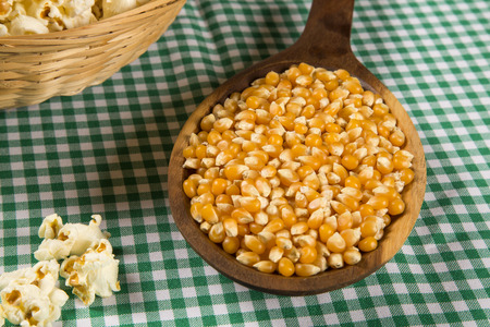 Ear of corn, revealing yellow kernels of maize in a wicker basketの写真素材