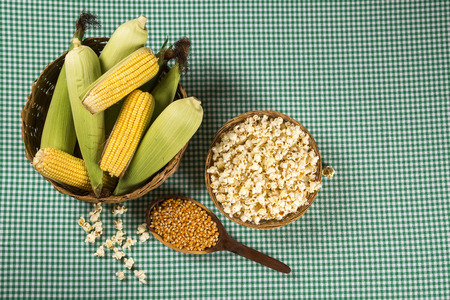 Ear of corn, revealing yellow kernels of maize in a wicker basketの写真素材