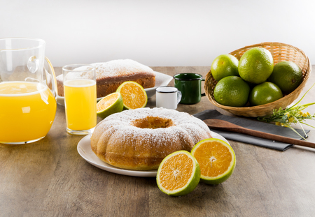 Orange cake on the table with fruits and juice.の写真素材