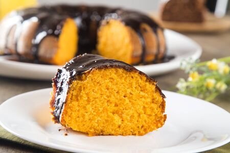 Carrot cake with chocolate and slice on the table.の写真素材