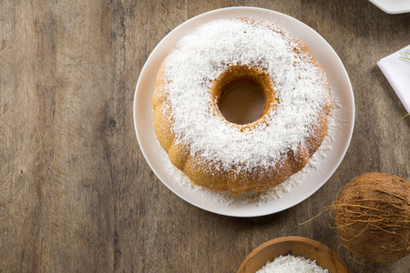 coconut cake with slice on the tableの写真素材