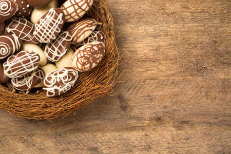 Chocolate Easter Eggs Over Wooden Background. Easter Egges desserts.の写真素材