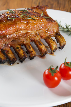 Tasty grilled ribs on board with vegetablesの写真素材