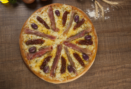 Traditional italian pizza with ingredients on wooden.の写真素材