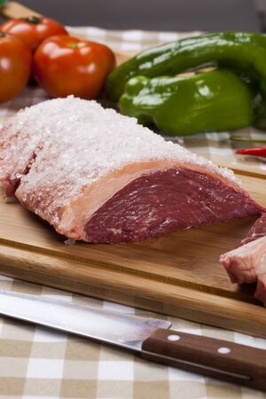 raw steak on wooden board with vegetablesの写真素材