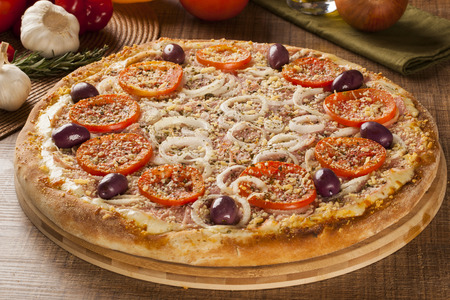 Traditional italian pizza with ingredients on wooden.の写真素材