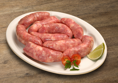 Fresh raw sausage on the old wooden background.の写真素材