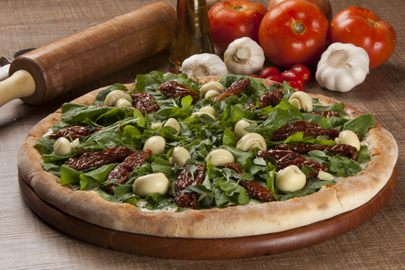 Traditional italian pizza with ingredients on wooden.の写真素材